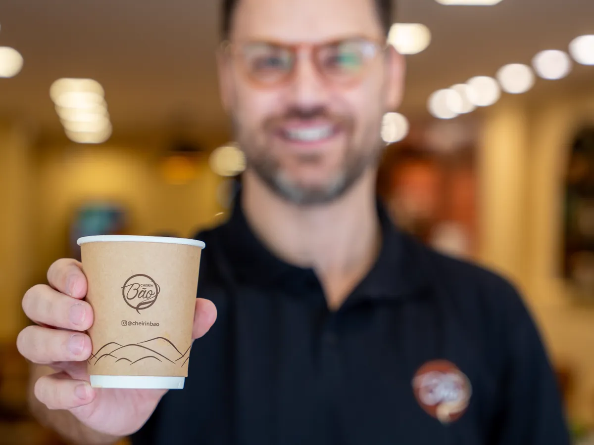 André, proprietário da Cheirin Bão Anchieta, oferecendo um copo de café Cheirin Bão
